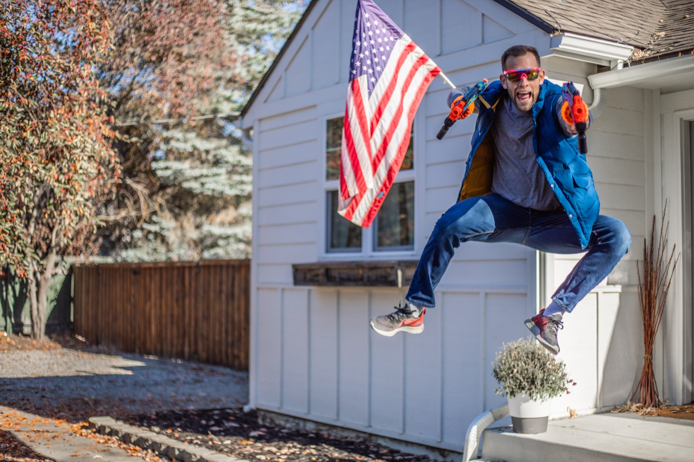 Chris Kiefer mid-jump holding an American flag in front of a white house