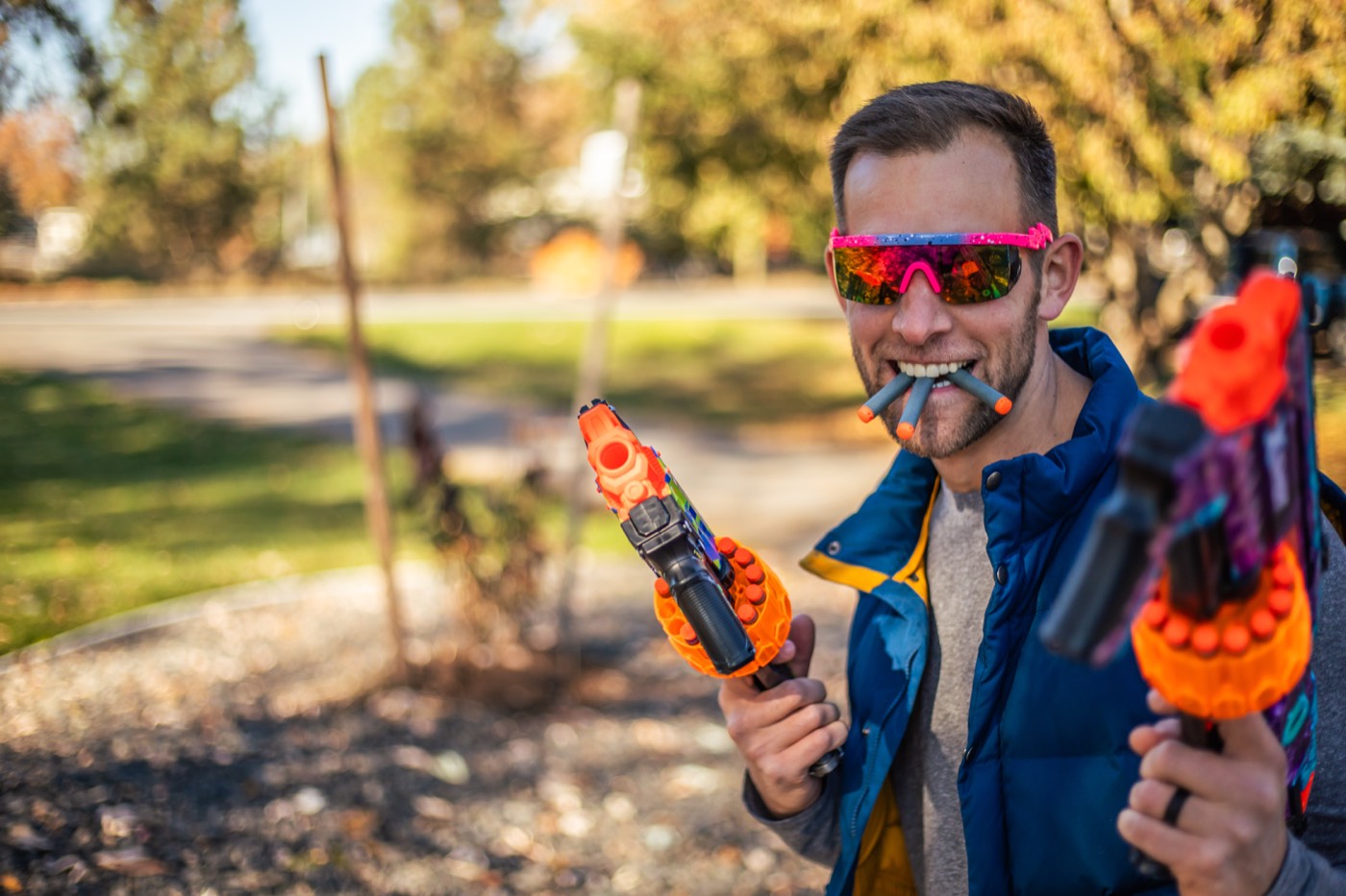Chris Kiefer in sunglasses holding two foam dart blasters